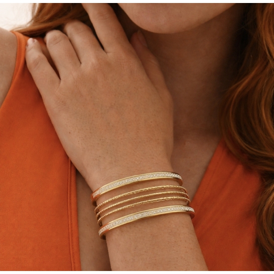 Bransoletka mankietowa w kolorze złotym.